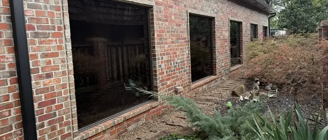 Brick home with residential window film installed by EHCO on four front picture windows, Northwest Arkansas