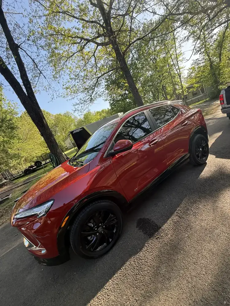 Red Buick Encore GX with ceramic window tint, photographed in a driveway