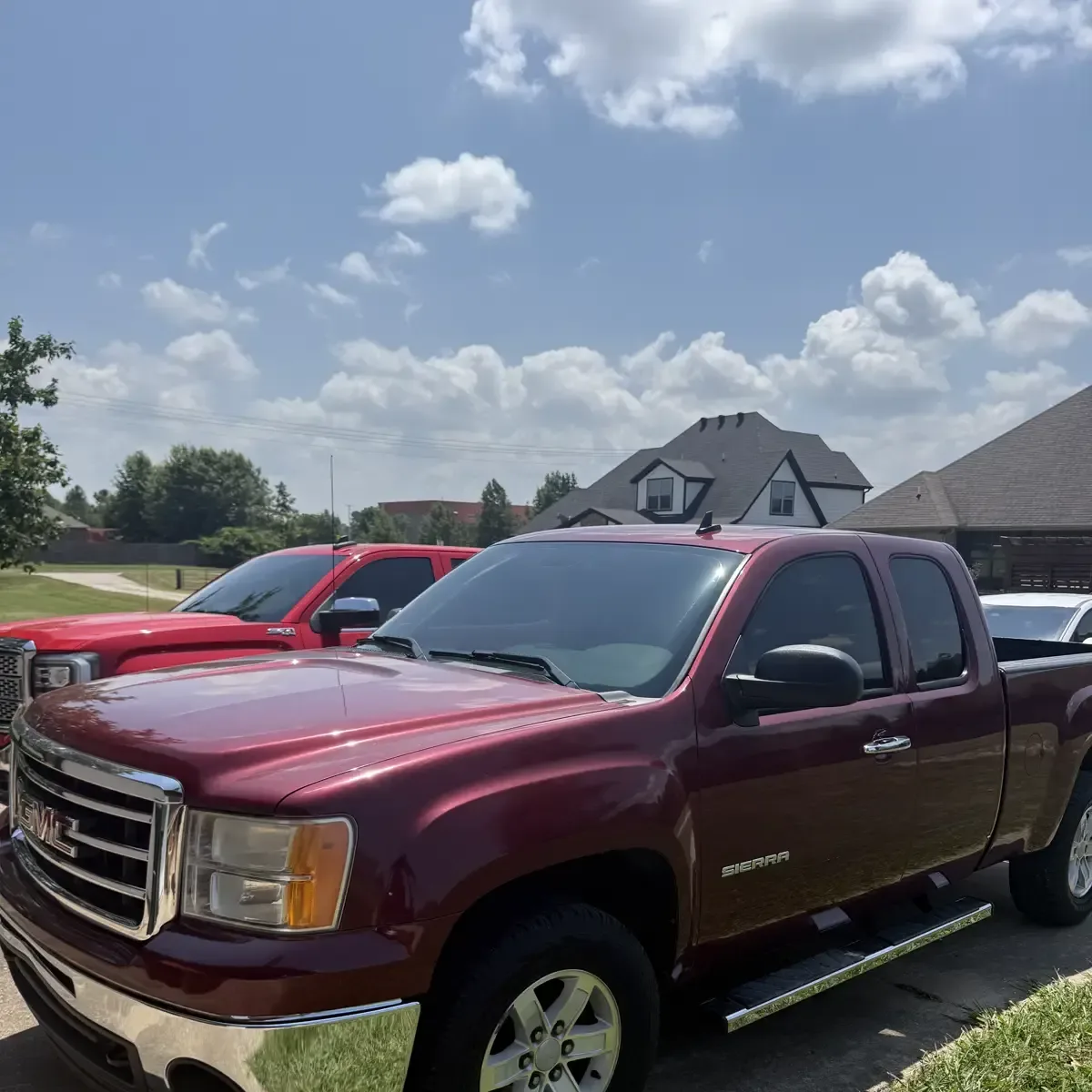 Maroon GMC Sierra pickup with dark window tint