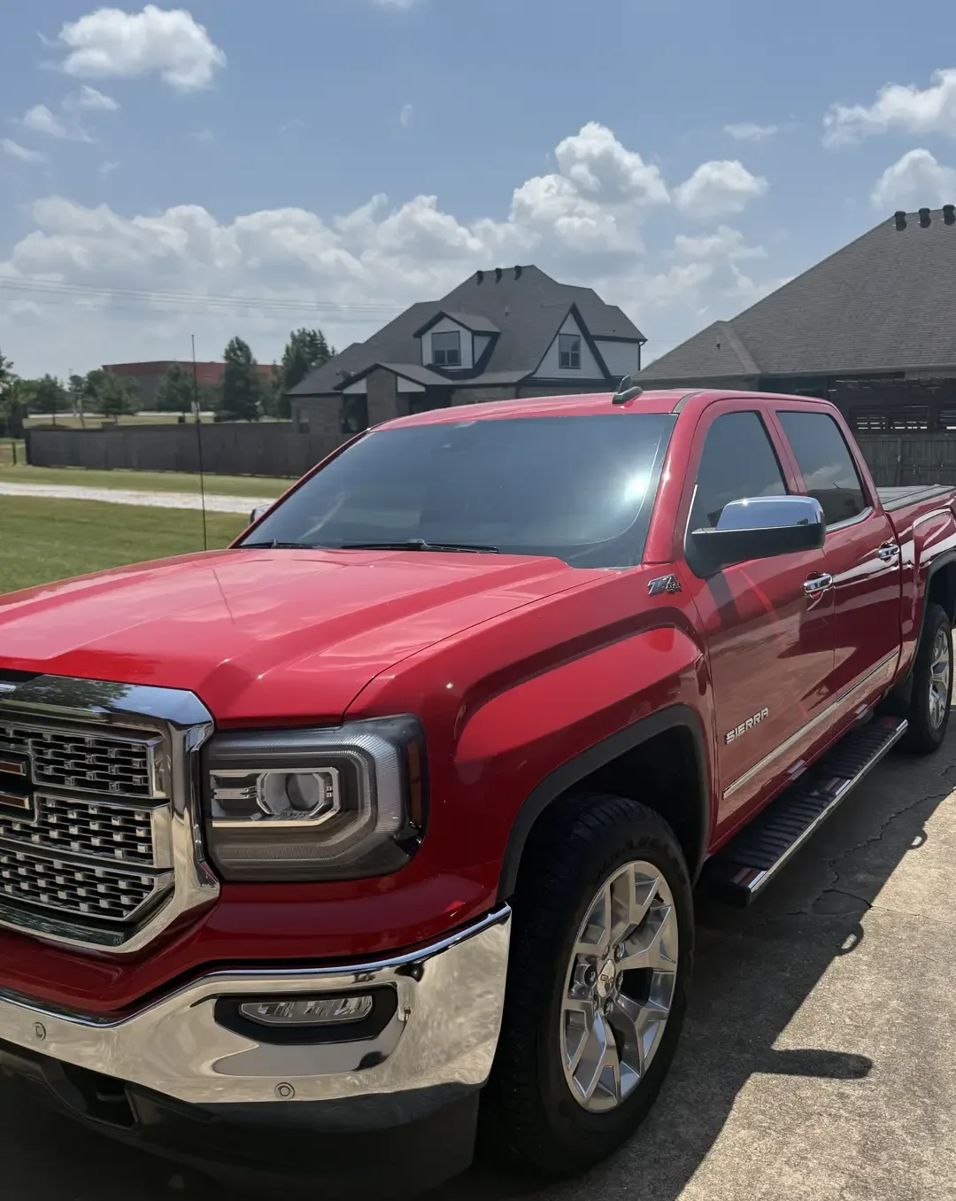 Red GMC Sierra 1500 Z71 pickup with tinted windows after a mobile install