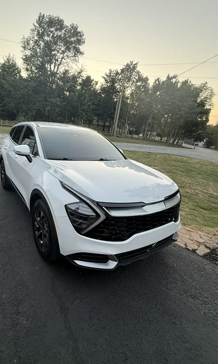 White Kia Sportage with new ceramic window tint at dusk, installed on-site by EHCO