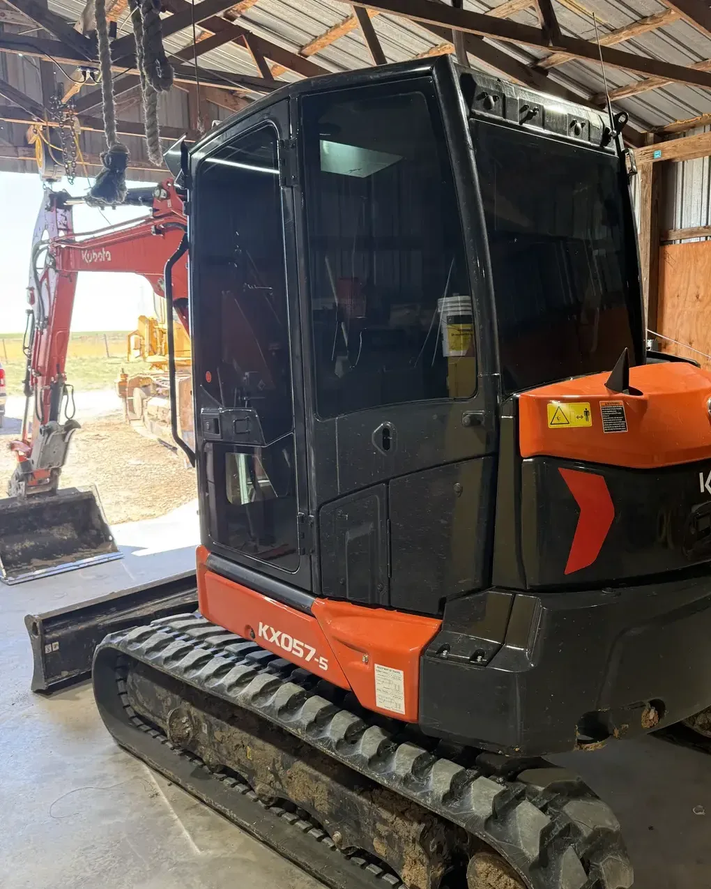 Kubota mini excavator with tinted cab glass on a job site