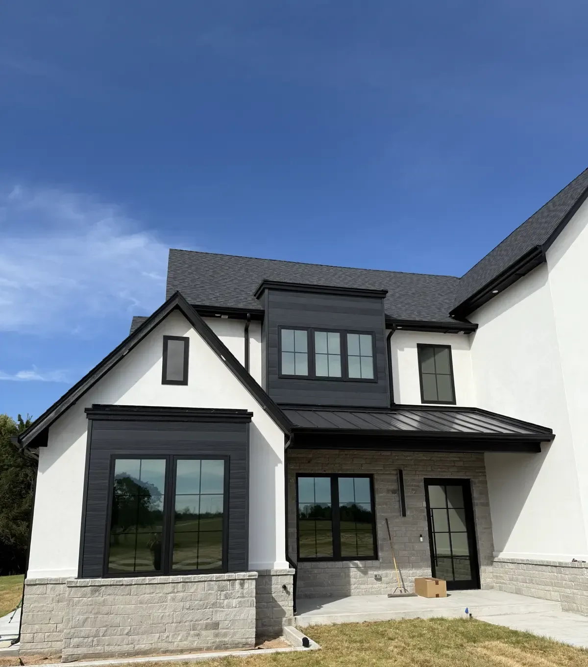 Closer front elevation of the same modern farmhouse, showing the tinted windows from the entry