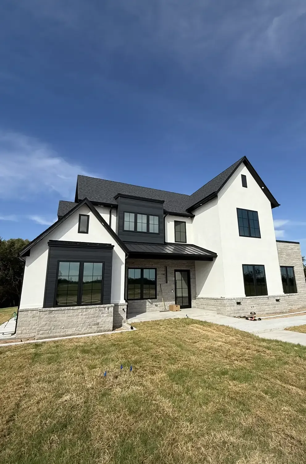 White modern farmhouse with black-framed windows tinted by EHCO in Northwest Arkansas